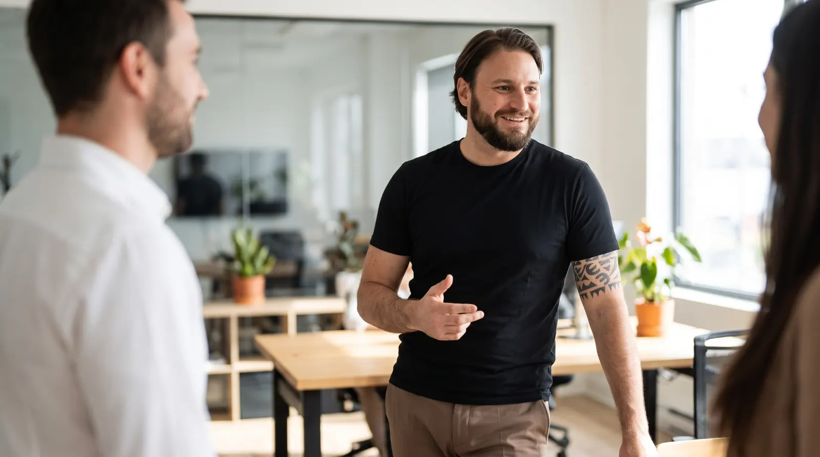 Alessio Vinassa smiling while speaking with collaborators in a bright office